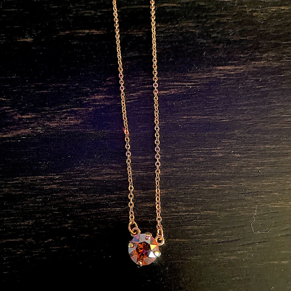8mm single crystal necklace. Never worn. With tags. Crystal is a deep pink.